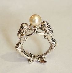 This is a beautiful two mermaids sterling silver  ring holding a 7.5 mm natural pearl  Can be ordered in sizes 6 to10 Mermaid Wedding Ring, Sculptural Rings, Two Mermaids, Mermaid Accessories, Silver Pearl Ring, Mermaid Ring, Pearl Rings, Dior Jewelry, Mermaid Style