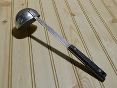 a metal object on top of a wooden table with a knife sticking out of it