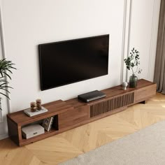 a flat screen tv sitting on top of a wooden entertainment center in a living room