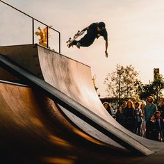 a man on a skateboard does a trick in the air at a skate park