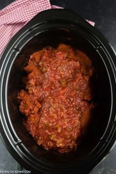 a crock pot filled with meat and sauce