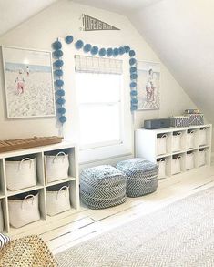 an attic bedroom with white storage units and blue decorations on the walls, along with baskets