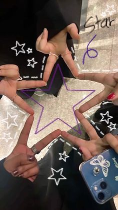 several people are holding their hands in the shape of a star with stars painted on them