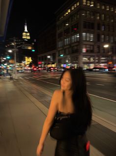 a woman walking down the street at night