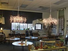 a room filled with tables and chairs under chandelier hanging from the ceiling above them