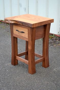 a small wooden table with two drawers on it