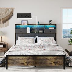 a bedroom with a bed, nightstands and pictures on the wall above it in front of a window