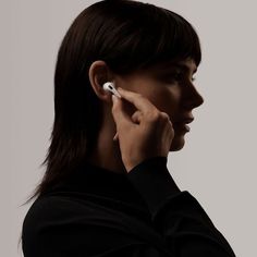 a woman is using her ear to hear something