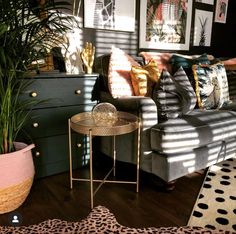 a living room filled with lots of furniture and decor on top of a hard wood floor