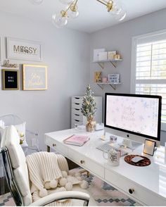 a white desk with a computer on it and a chair in front of the monitor