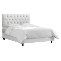 a white bed with tufted headboard and foot board is shown in front of a white wall