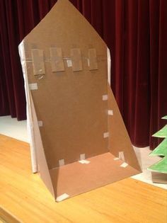 an open cardboard box sitting on top of a wooden table next to a christmas tree