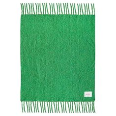 a green rug with fringes on the top and bottom, against a white background