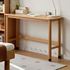 a wooden table with a lamp on top of it next to a book shelf and chair