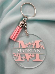 a pink keychain with a tassel hanging from it's side on a blue cloth