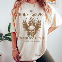 Get ready to be OBSESSED with your new Acotar The Bone Carver shirt. It's the cutest and most trendy way to combine all those important trendy mystical and literature shirt vibes! This is the perfect dark academia ACOTAR shirt!  * Q U I C K * F A C T S * All shirts are UNISEX ✺  100%  ringspun cotton (fiber content may vary for different colors) ✺  Soft-washed, garment-dyed fabric brings extra coziness ✺  Wash and dry normally (on cool for best results) ✺  Sewn-in twill label * S I Z I N G * ✺ For an oversized fit, select two or three sizes up from your normal size ✺ Model is wearing size L  ✺ Sizing runs true to size ✺ Relaxed fit ✺ Most women find their typical size works best, since they are meant to fit a touch loose ✺ See Size guide and fit in images          * S H I P P I N G * T I M The Bone Carver, Bone Carver, Strappy Backless Dress, Acotar Shirt, Backless Dress Summer, Book Clothes, Summer Fashion Beach, Short Playsuit, Womens Playsuits