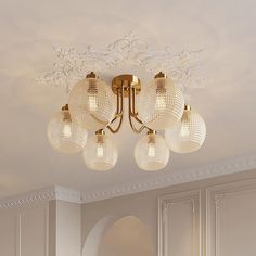 a chandelier hanging from the ceiling in a room with white walls and furniture