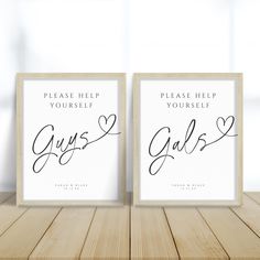 two framed posters with the words guess and galas on them sitting on a wooden table