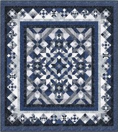 a blue and white quilt with an intricate design on the center, surrounded by squares