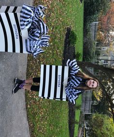 two women dressed in black and white striped outfits