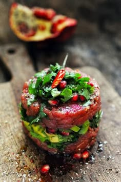 a sandwich with meat, lettuce and tomatoes on it sitting on a cutting board