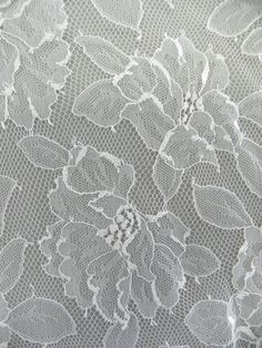 an image of white lace with flowers on it