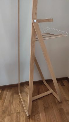 a wooden stand with a mirror on top of it in front of a white wall