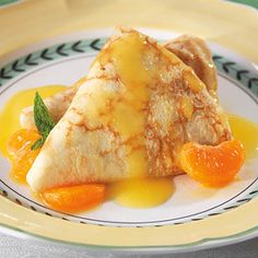 some food is sitting on a plate with oranges and sauce in the middle,