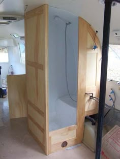 the inside of a bathroom that is being built with wood and glass in place for it to be used as a shower