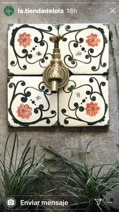 a wall mounted faucet on the side of a building with flowers painted on it