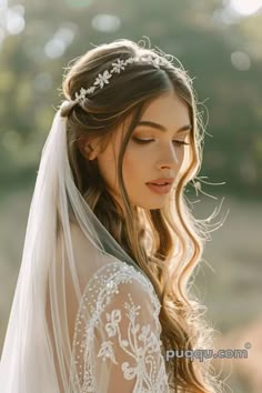 a woman wearing a veil with flowers on it and a tiara in her hair