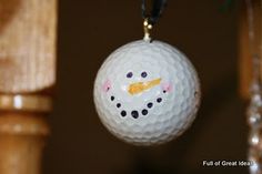 a golf ball ornament with a snowman face on it