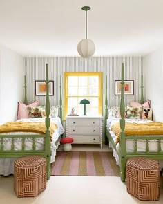 two beds in a bedroom with yellow and green decor on the walls, along with a white chest of drawers