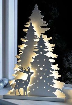 a paper cut out of a christmas tree with stars on it and a deer standing next to it