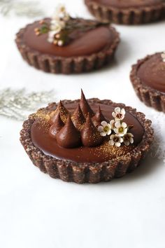 three chocolate tarts with flowers on top