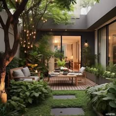 an outdoor living area with grass and plants on the ground, lights strung from above