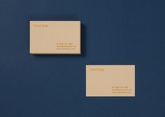 two business cards sitting side by side on a blue surface