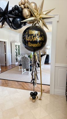 a black and gold balloon is on top of a stand in the middle of a room