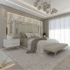 a large white bed sitting under a chandelier in a bedroom next to a window