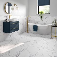 a bathroom with white marble floors and blue accents on the walls, along with a claw foot tub