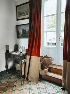 a room with a window, rugs and pictures on the wall next to it