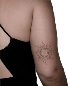 a woman's arm with a tattoo on the back of her shoulder and sun in the middle