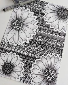 a drawing of sunflowers on top of a piece of paper next to a marker