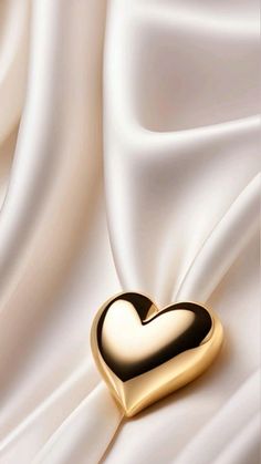 a gold heart on white silk