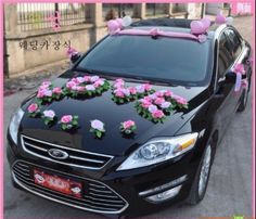 a black car with pink flowers on the hood