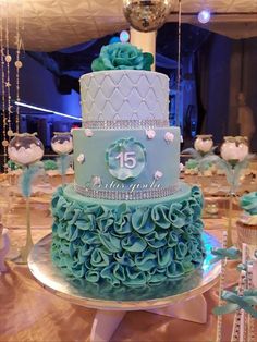 a blue and white wedding cake sitting on top of a table