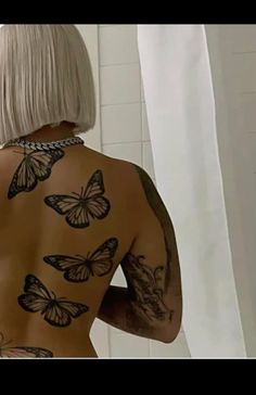 a woman with white hair and tattoos on her back