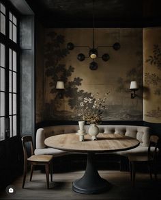 a dining room table with two chairs and a vase on the table in front of it