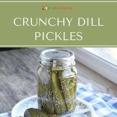 pickles in a jar on a plate with the title crunchy dill pickles