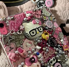 a cell phone covered in lots of pink and silver items